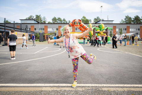 Hymyilevä tyttö koulun edessä.