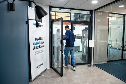 Kaksi ihmistä menossa kirjaston ovesta sisälle.