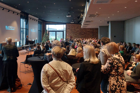 Avoimen neuovotelupäivillä yleisö kuuntelee esitystä