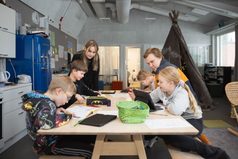 Opettajat tekemässä koululaisten kanssa tehtäviä.