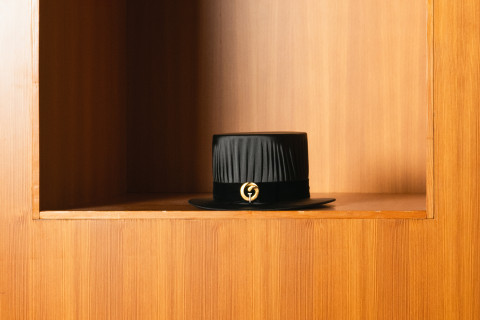 Tohtorihattu puisella hyllyllä.