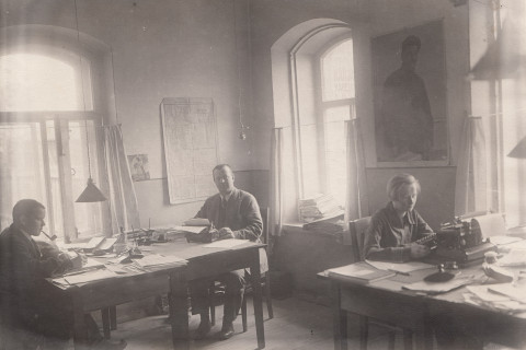 Ihmisiä toimistopöytien ääressä.