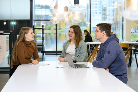 Opiskelijoita Snellmanian ala-aulassa pöydän ääressä