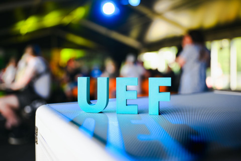 UEF-kirjaimet ja yleisöä taustalla.