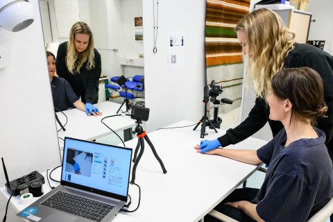 Fysioterapeutti auttaa potilasta harjoittamaan käsivarren lihaksia.