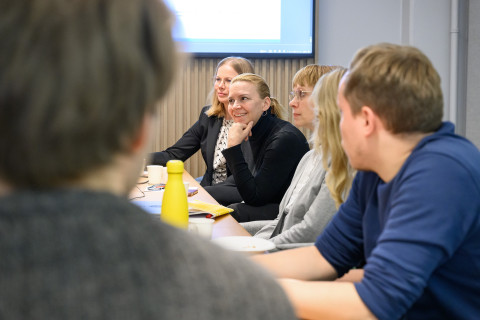 Ihmisiä kokoushuoneessa.