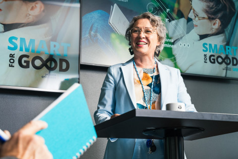 Henkilö pitää puheenvuoroa luentosalissa