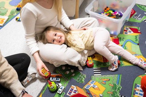Varhaiskasvatuksen opiskelija leikkii lapsen kanssa päiväkodissa.