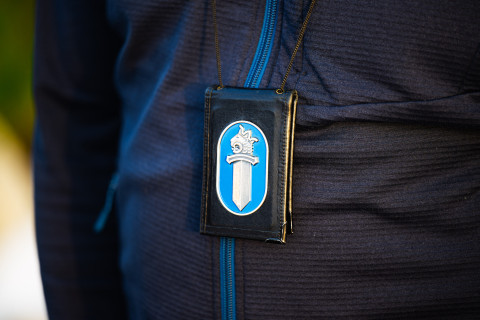Poliisin lätkä kaulanauhassa.