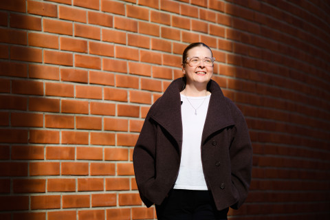 Opiskelija Tea Salo kampusrakennuksen seinustalla