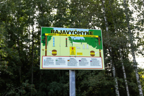 Opastaulu rajavyöhykkeestä taustalla koivumetsä.