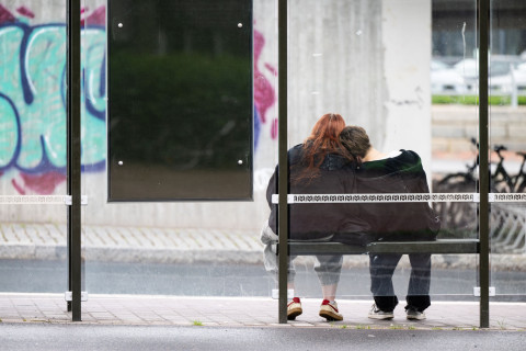 Two people at a bus stop.