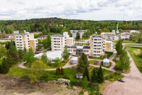 Ilmakuva kerrostaloaluesta, jonka ympärillä on vihreää luontoa.