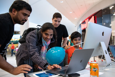 Nainen ja nuori poika katsovat tutkimustuloksia tietokoneelta kahden tutkijan kanssa.