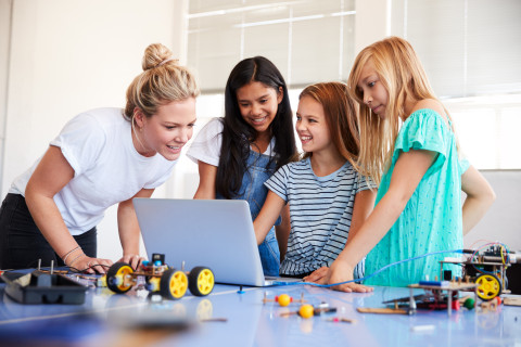 Teacher and pupils on a computer.