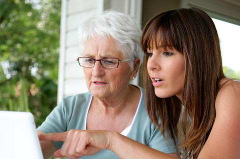 Vanhempi ja nuorempi nainen tietokoneella.