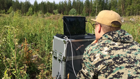 Lennonjohtopaikka hakkuuaukealla. Tutkija Anton Kuzmin seuraa fixed wing -dronelennon edistymistä.