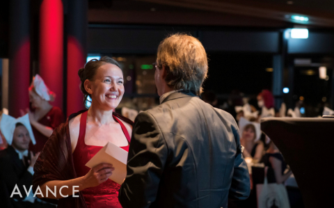 Nainen vastaanottaa palkinnon juhlatilaisuudesssa.