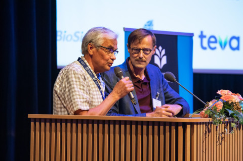 Poitlaan puheenvuoro Kuopio Alzheimer Symposiumissa 2022. Oikealla Heikki Tanila.