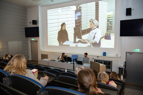Ihmisiä auditoriossa.