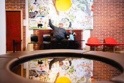 Antti Juvonen esittelee taustalla näkyvää taidetta.