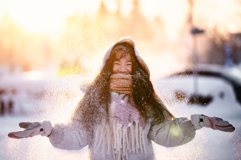 Student standing in snow and smiling