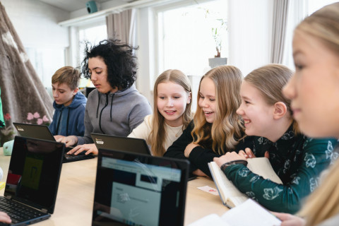 Pupils studying together as a group around a table.