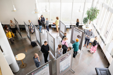Ihmisiä kasvatustieteen posterinäyttelyssä.
