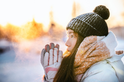 Student in winter outside with warm clothes, sun is shining