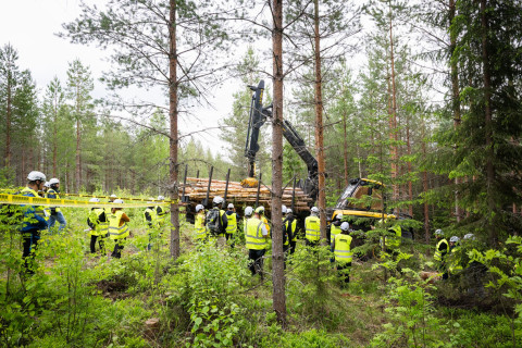 Ihmisiä metsäkoneen ympärillä.