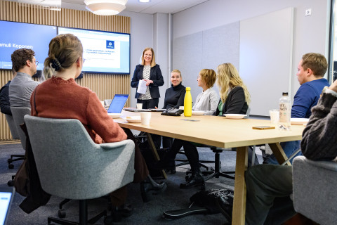 Ihmisiä kokoushuoneessa.