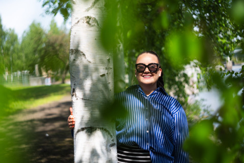 Ruotsin kielen opiskelija Riikka Kinnunen aurinkolasit päässään kesäisessä maisemassa