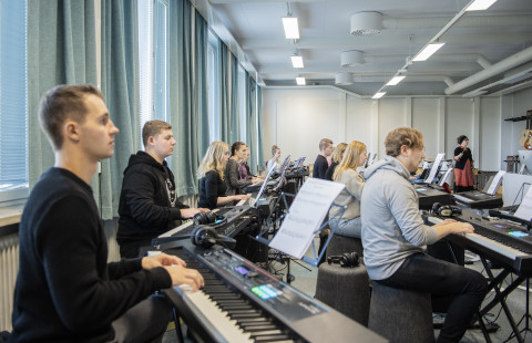 Opiskelijat soittavat pianoa