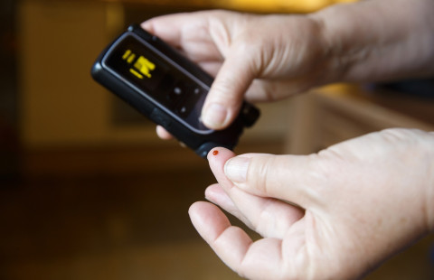 Diabetic patient testing her blood for sugar level