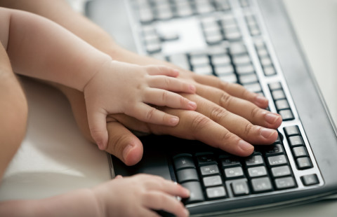Aikuisen ja lapsen kädet tietokoneen näppäimistöllä