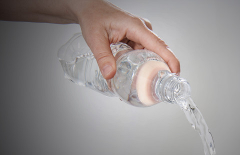 Vesipullosta kaadetaan vettä.