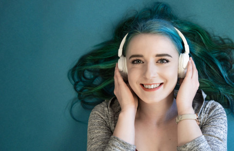 Opiskelija kuuntelee kuulokkeilla