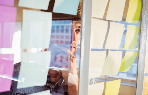 Man reading sticky notes.