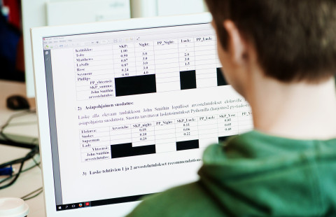 Mies työskentelee tietokoneella.