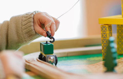 lapsi leikkii puujunalla