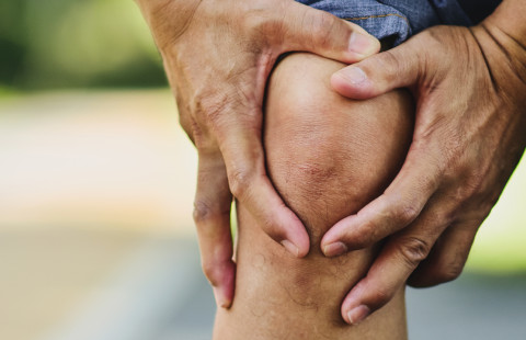 Mies pitelee kipeää polvea.