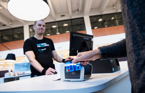 Customer paying at the library service desk.