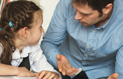 Teacher dicussing with a young student.