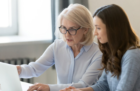 Vanhempi ja nuorempi nainen tietokoneella.