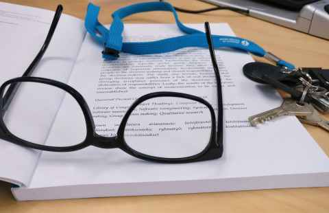 Silmälasit ja avaimet kirjan päällä.