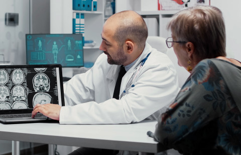 Lääkäri selittää aivokuvien tuloksia potilaalle.