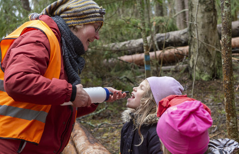 Opettaja antaa vettä lapselle.