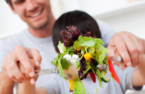 Man and boy making salad.