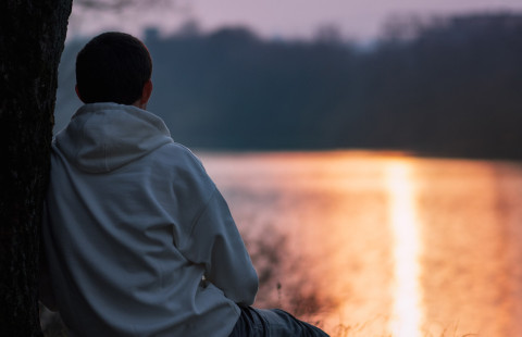 Lapsi istuu rannalla.