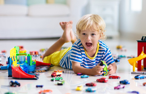 Lapsi leikkii pikkuautoilla